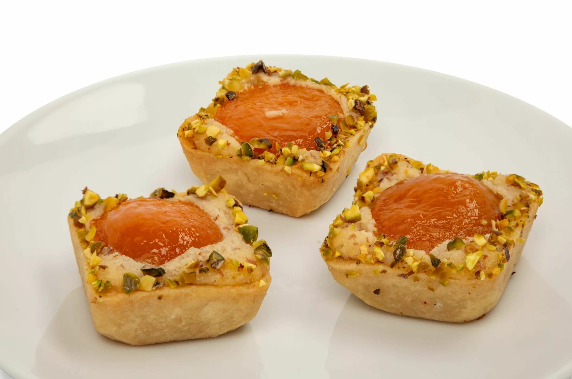 PLU 9027 Apricot Pistachio Tart x3 Baked with apricot halves, apricot glace in a sugar crust, and topped with crunchy pistachios. Includes 6 pieces.
